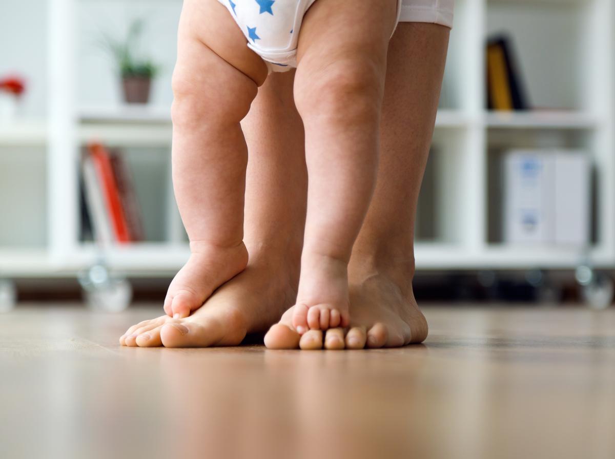 Baby toes standing on mother's toes