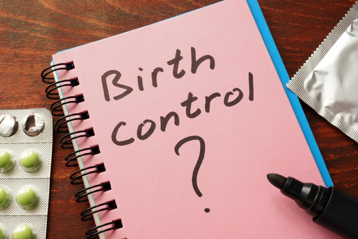 Package of "the pill" and a notebook with "Birth control?" written on it