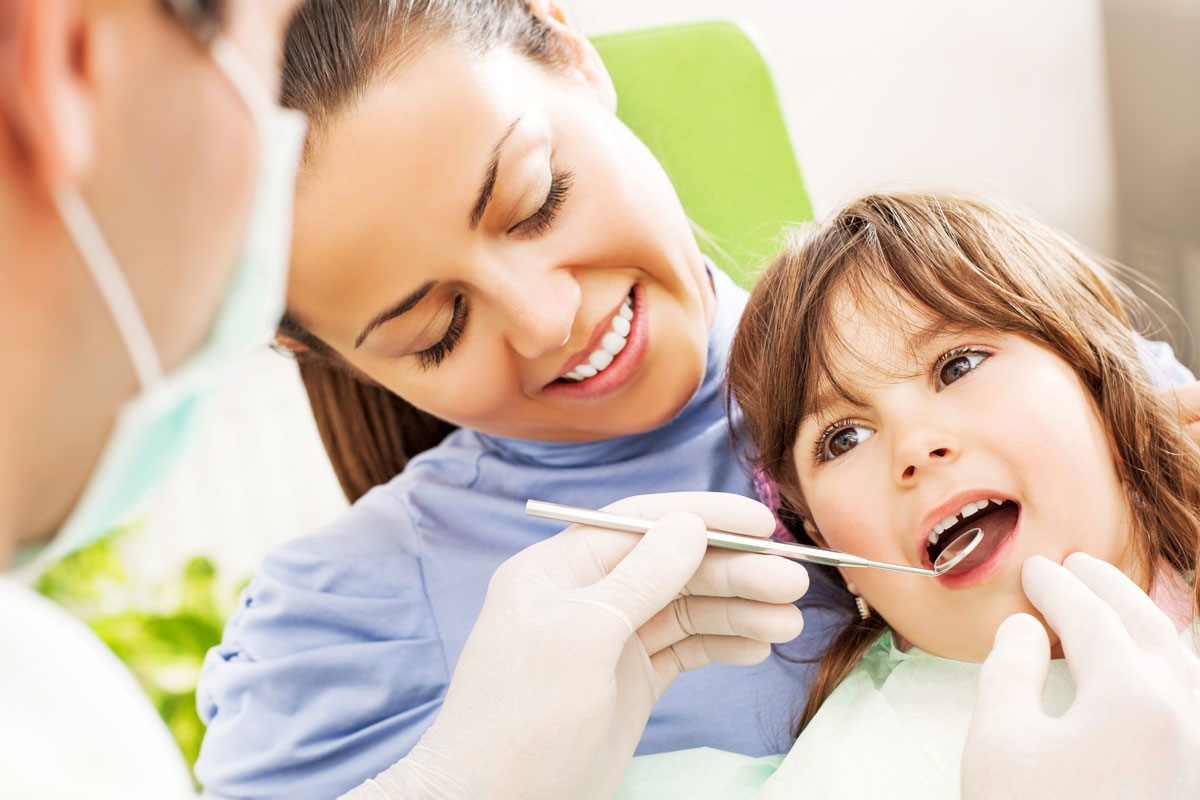 Hygienist looking into child's mouth