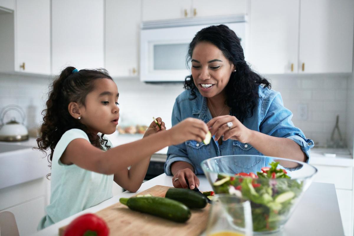 Mother and daughter in the kitchen making a salad together