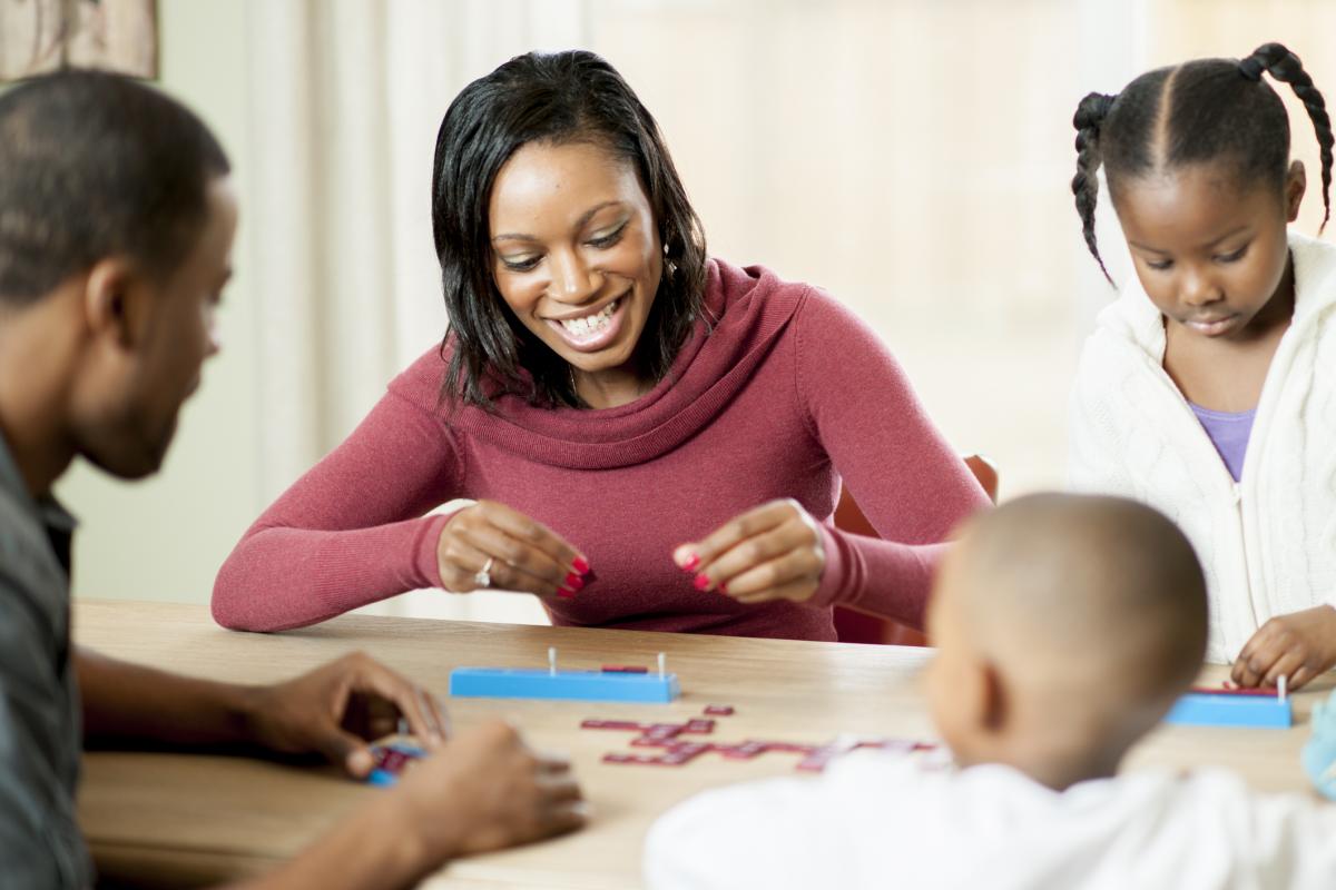 Family of four playing a board game together