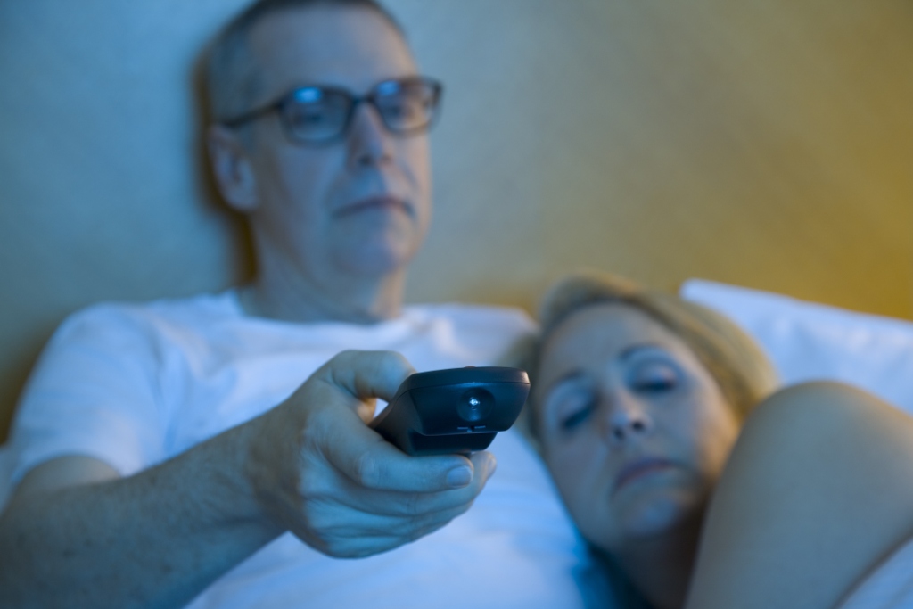 Couple watching TV in bed