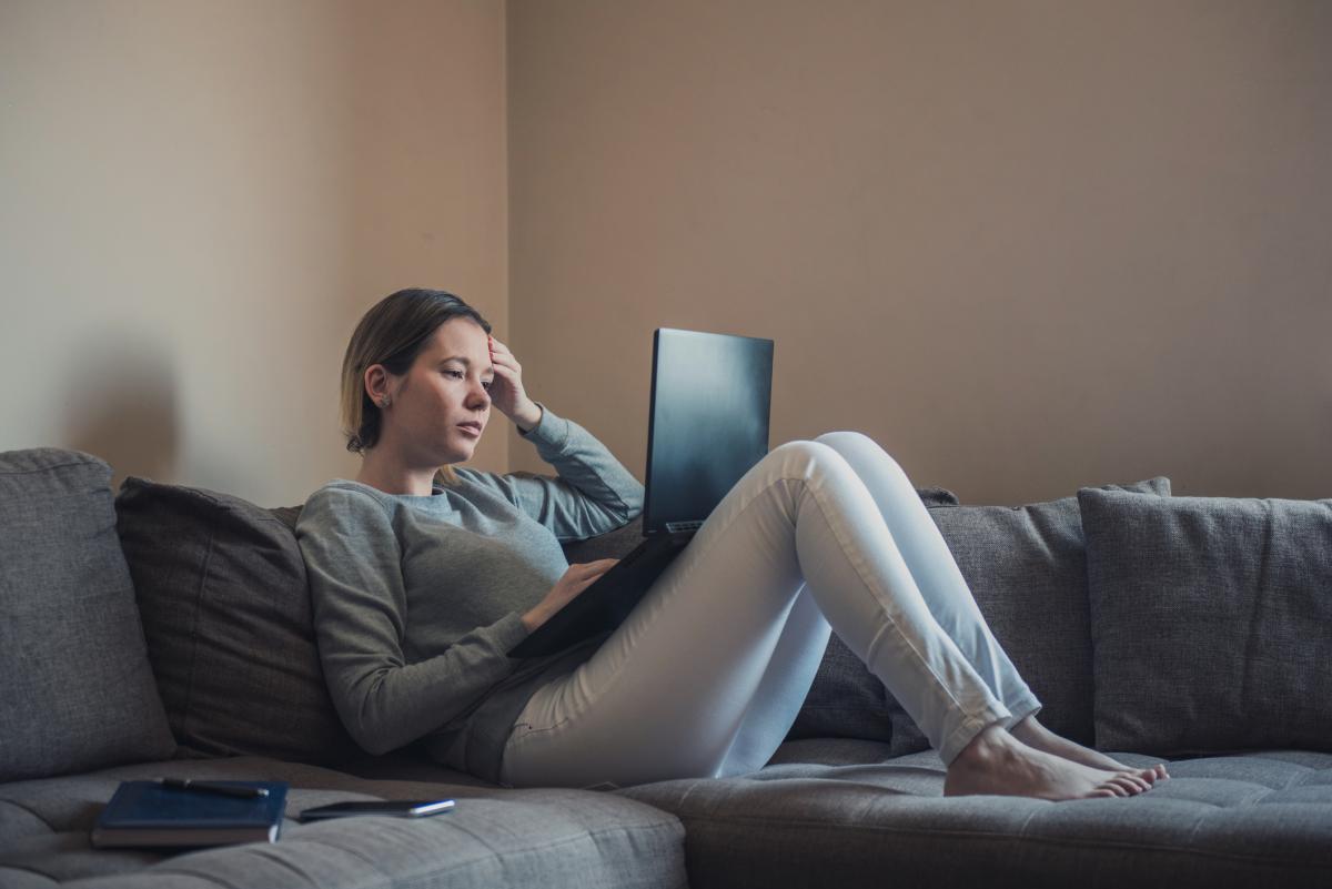 Woman working on her laptop at home on couch