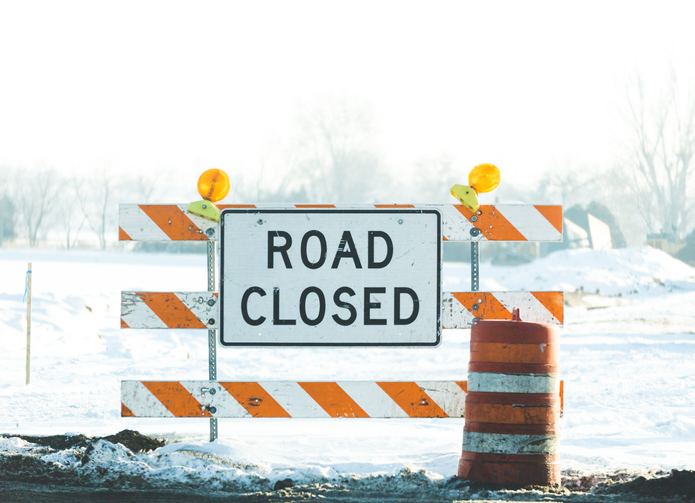 Road closed sign on snowy road