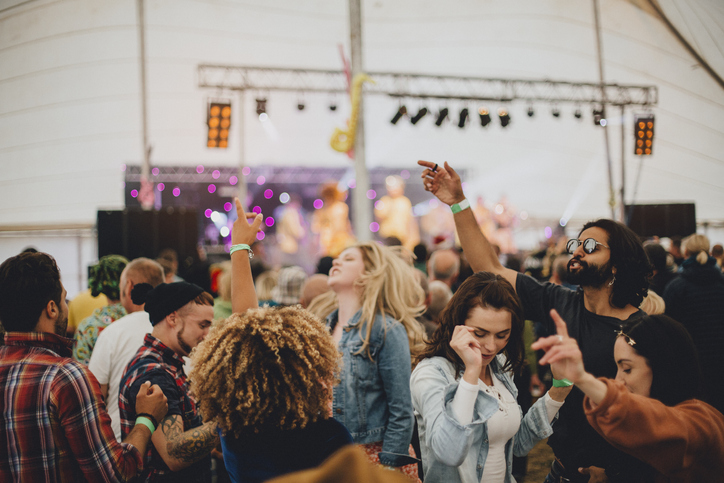 Concert-goers dancing inside a huge tent