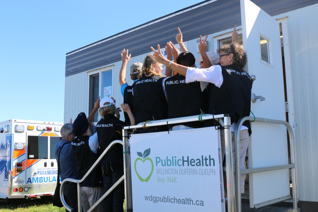 PHIs at an event wearing black vests that say "Public Health" on the backs