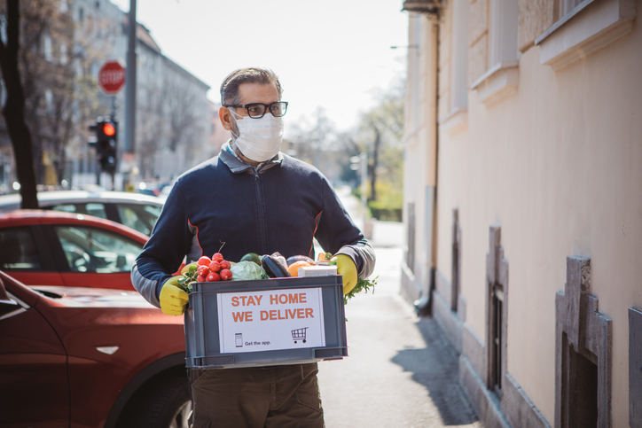 Man in mask delivering groceries