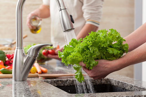 washing lettuce in a kitchen sink