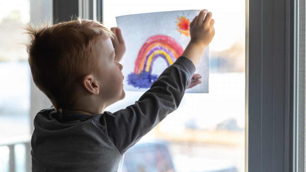 Young child posting drawing to window