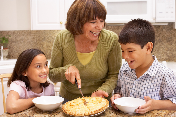 Grandma cutting pie for grandchildren