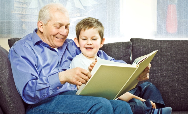 Grandfather reading to grandson