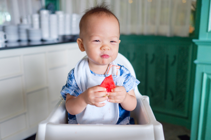 Toddler boy eating watermelon