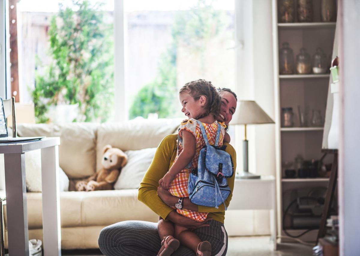 A mother hugs her daughter before they leave home on the first day of school