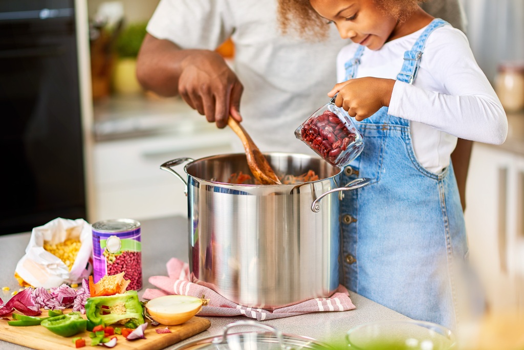 Father and daughter making bean chili together in the kitchen