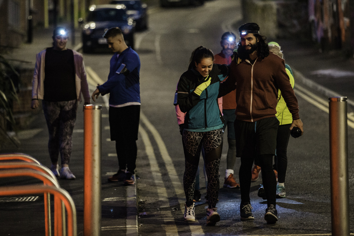 Friends walking together down a city street at night