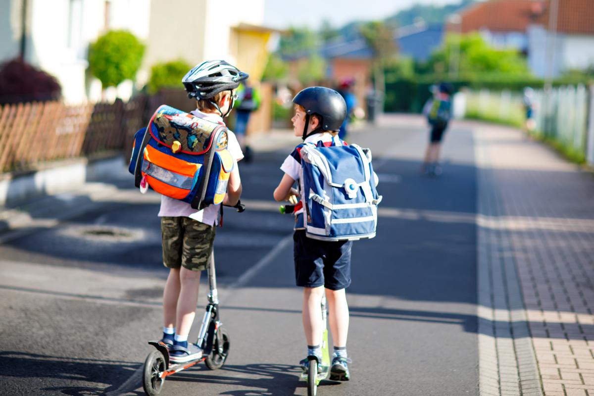 Friends riding to school on scooters