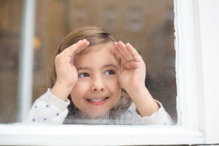 Young girl looking out a window
