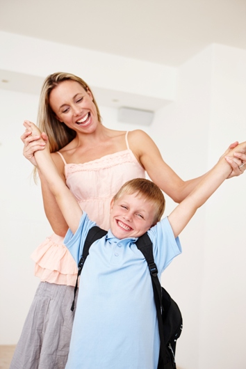 Happy mother and elementary-aged son dancing