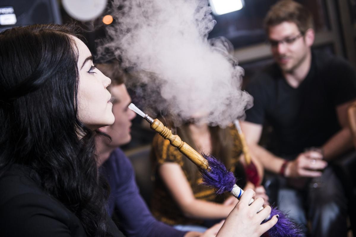 Young adults smoking hookahs