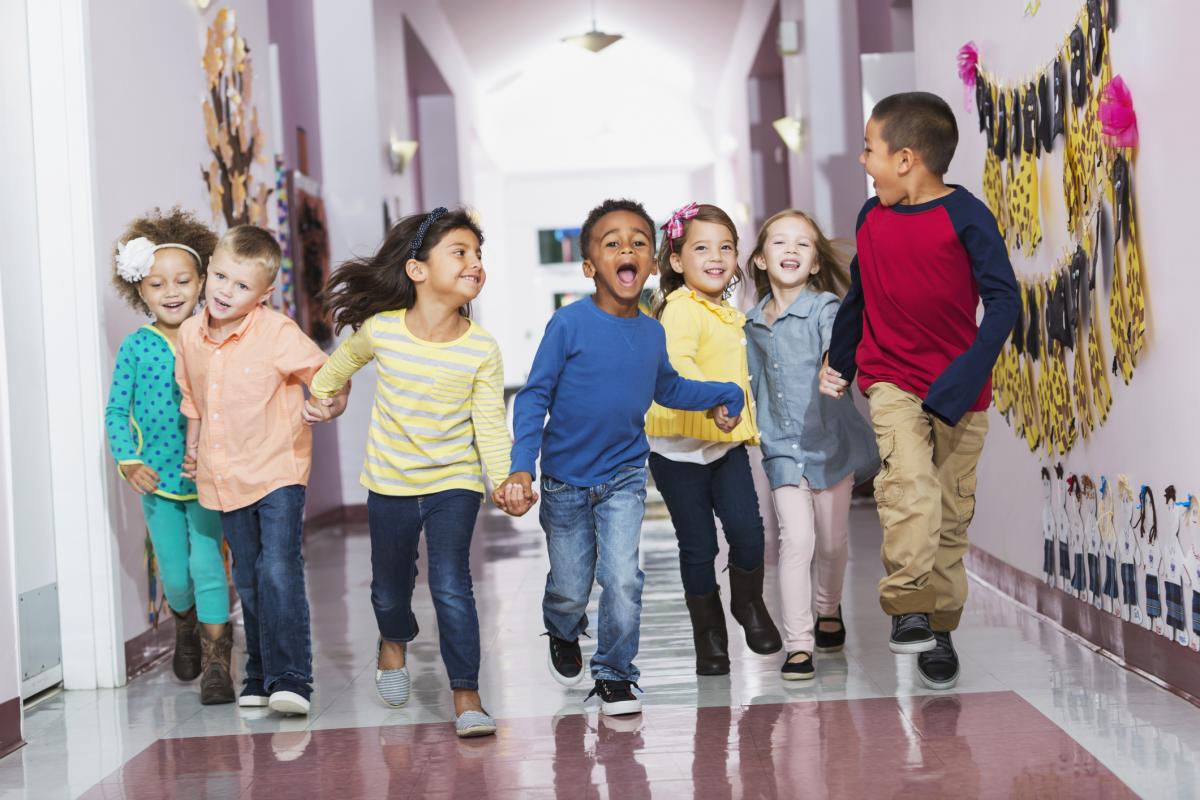 Group of happy elementary children in school hallway
