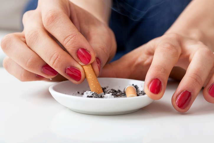 Woman putting out cigarette in ashtray