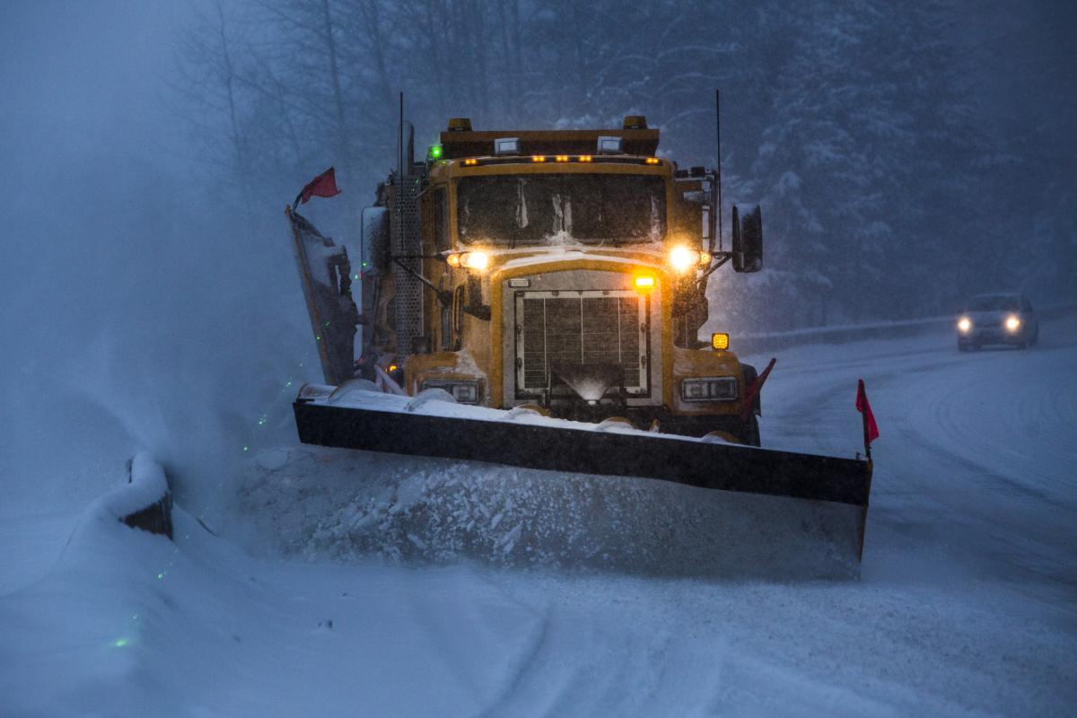 Snowplow pushing snow off the highway