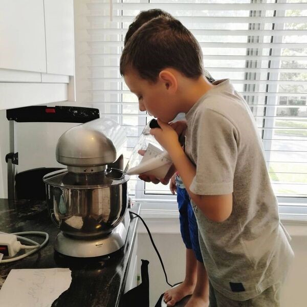 kids pouring ingredients into a mixer