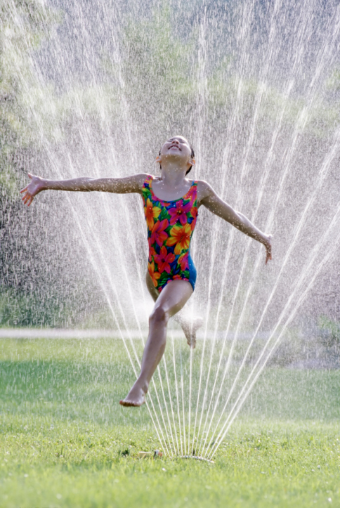 Child running through sprinkler