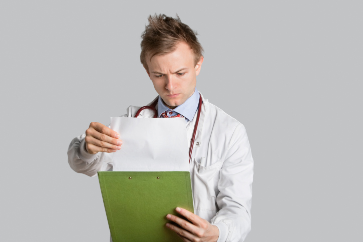 Doctor reading clipboard