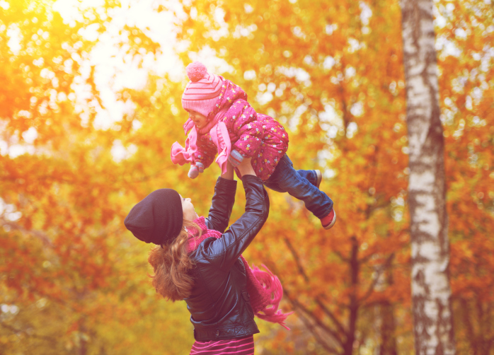 Mom and daughter of for a walk in fall