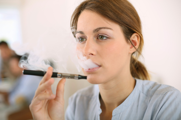 Woman smoking e-cigarette inside