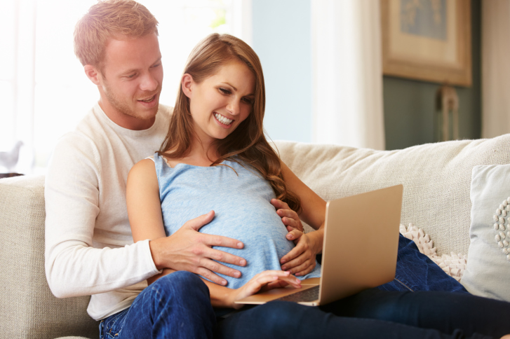 pregnant couple using computer