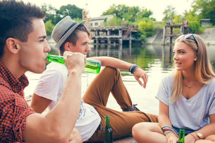 Friends drinking by lake