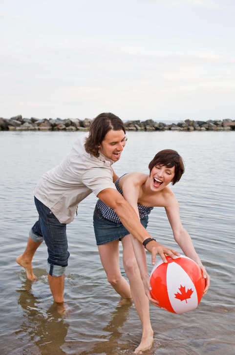 Couple playing in water with Canada Day beach ball