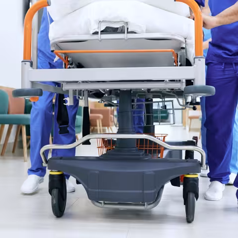 Medical staff pushing patient on medical gurney at emergency department, bottom view. 