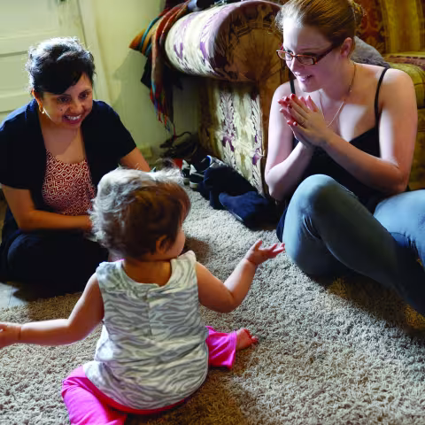 Home visitor working with toddler and mom
