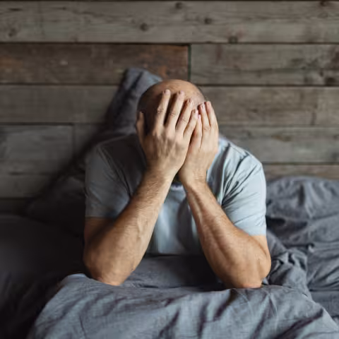 Mature man in bed with headache