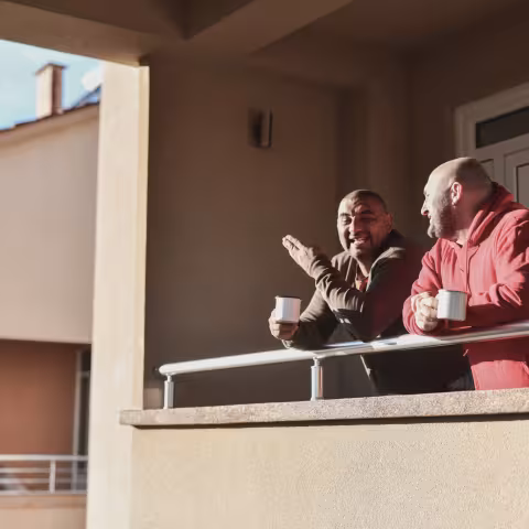 Two males enjoying coffee on their balcony