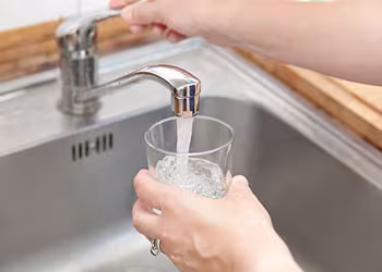 Glass filling with water from tap