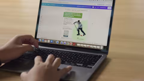 Image of someone on a laptop designing a vaccine promotional poster.