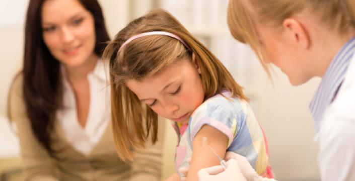 Nurse administering a vaccine injection to girl