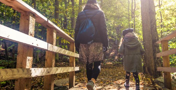 A mom and daughter hiking in the woods
