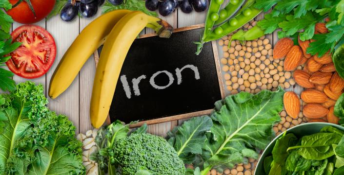 Plant based sources of iron background. broccoli, banana, tomatoes, almond, spinach, green peas, collards, grapes, kale, soya been and nuts are iron-rich foods. - stock photo