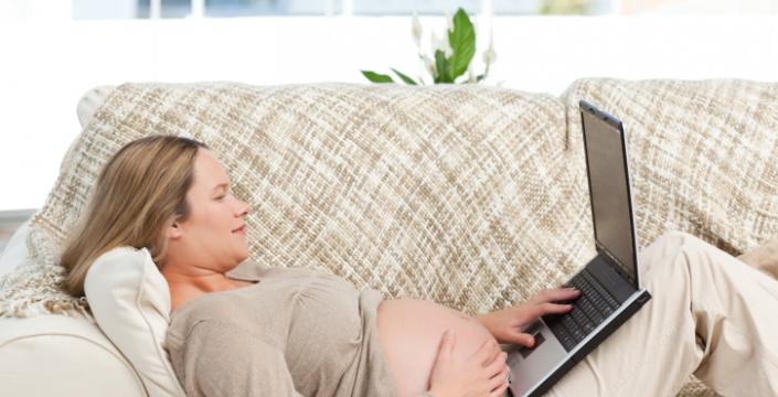 Expecting mother using computer laptop