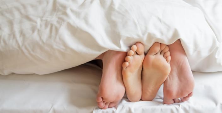 Couples feet in bed