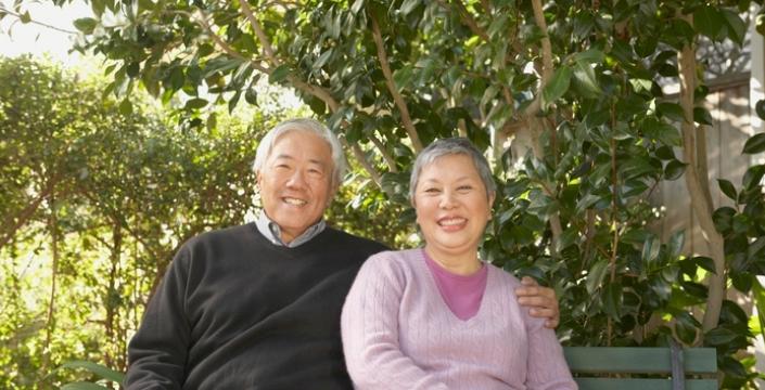 Smiling retired couple sitting on bench