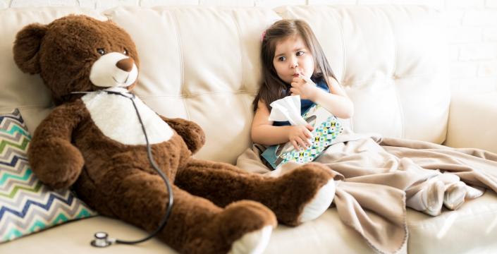 A sick toddler girl with her teddy bear