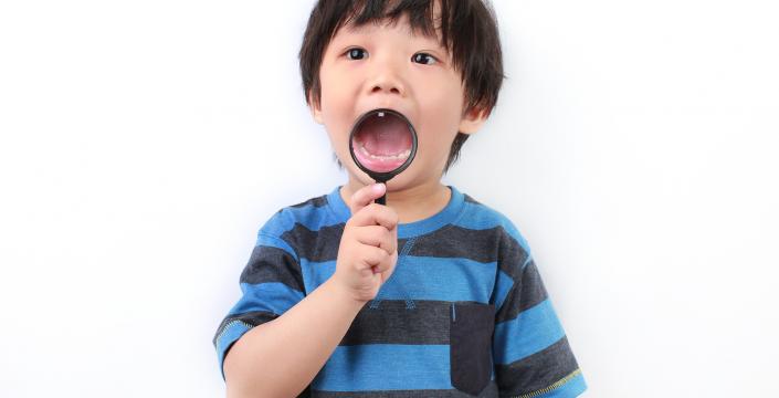 Toddler examining his teeth