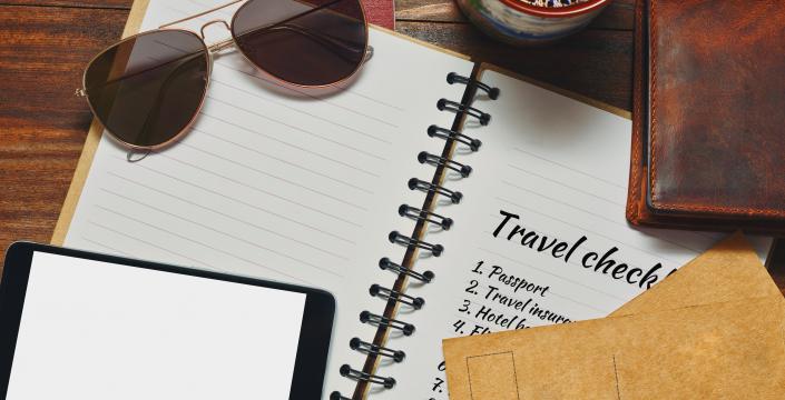Travel supplies - a checklist, sunglasses, passport and wallet