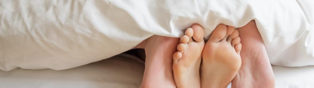 Couples feet in bed